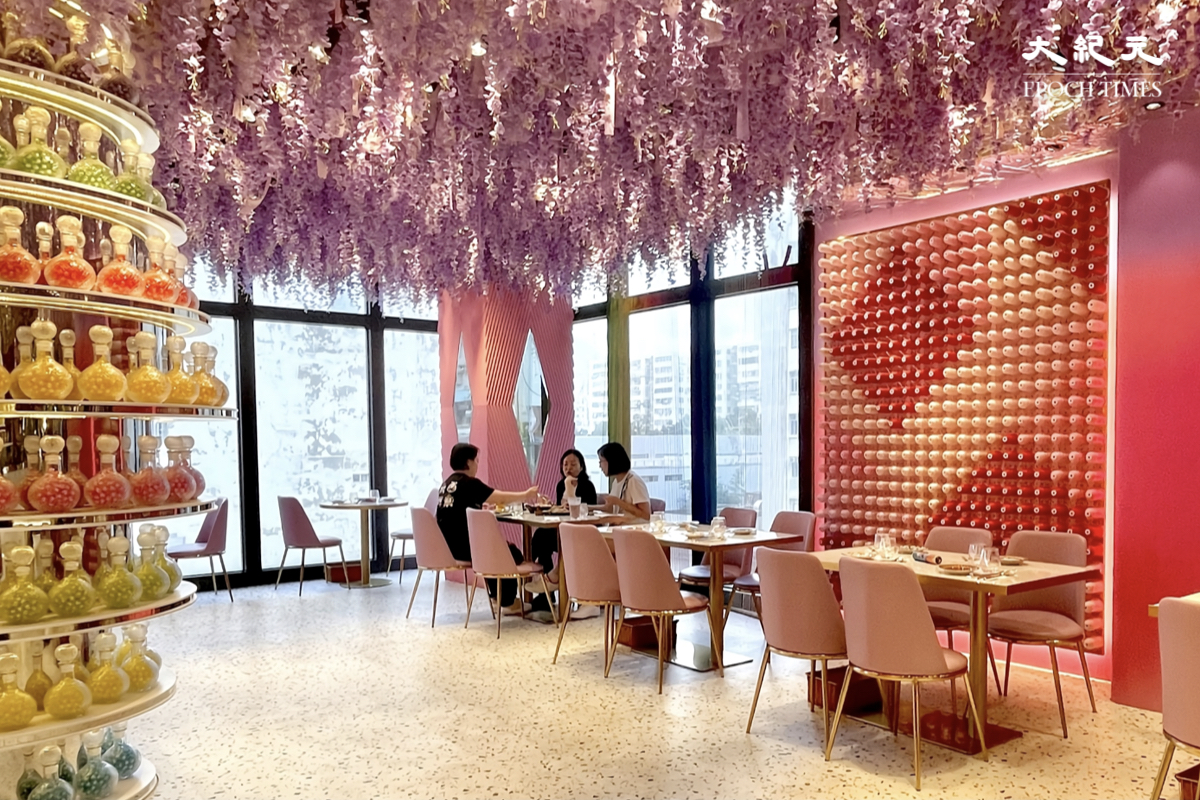 從落地玻璃窗外透進餐廳的陽光，配上粉色系紫藤花天花吊飾，有種身處異地的感覺。（樂賢／大紀元）