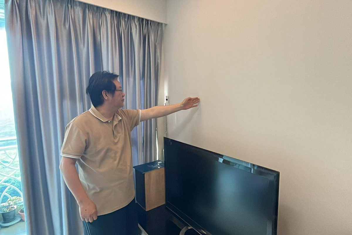 涉事單位樓上一層31樓同單位的住戶陳先生，對記者展示該主力牆位置。（鄭兆東／大紀元）