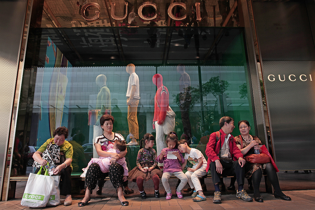 經過3年疫情，中國人的錢包縮水了，整體社會出現更節儉的趨勢。圖為香港一家Gucci店外的大陸遊客。（AFP/Getty Images）