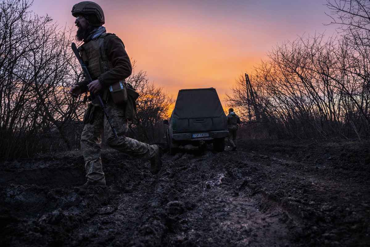 2023年3月4日，烏克蘭突擊旅的一名士兵在巴赫穆特附近走過泥濘的道路，運輸和定位英國製造的L118 105毫米榴彈砲。（John Moore/Getty Images）