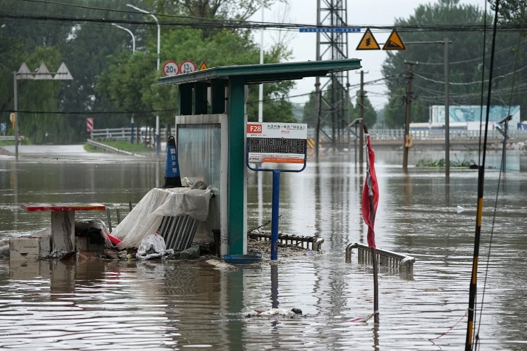 圖為2023年7月31日，北京房山區暴雨後，洪水泛濫的河流附近被淹沒的公交車站。（CNS / AFP）