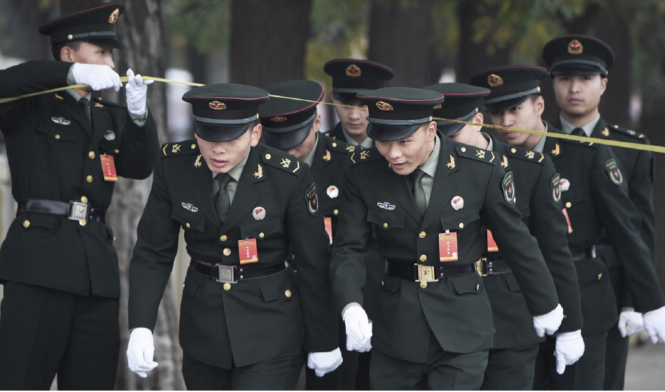 中共軍中監控嚴厲。示意圖：2017年10月25日，北京大會堂外，在中共最高決策機構——中央政治局常委亮相前，中國士兵在隔離欄下行進。(Greg Baker/AFP via Getty Images)