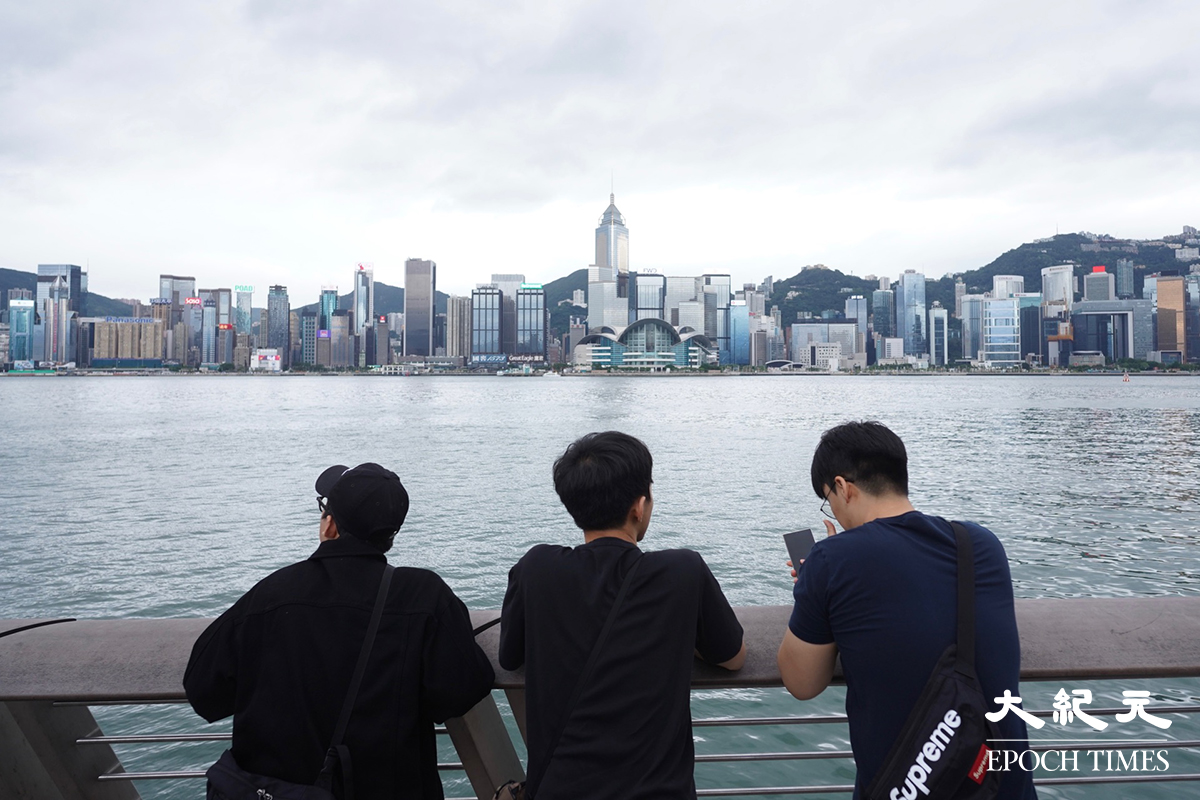 在尖沙咀維港一帶陰雲密布，間中有雨，但仍有不少人觀光。（劉駿軒／大紀元）