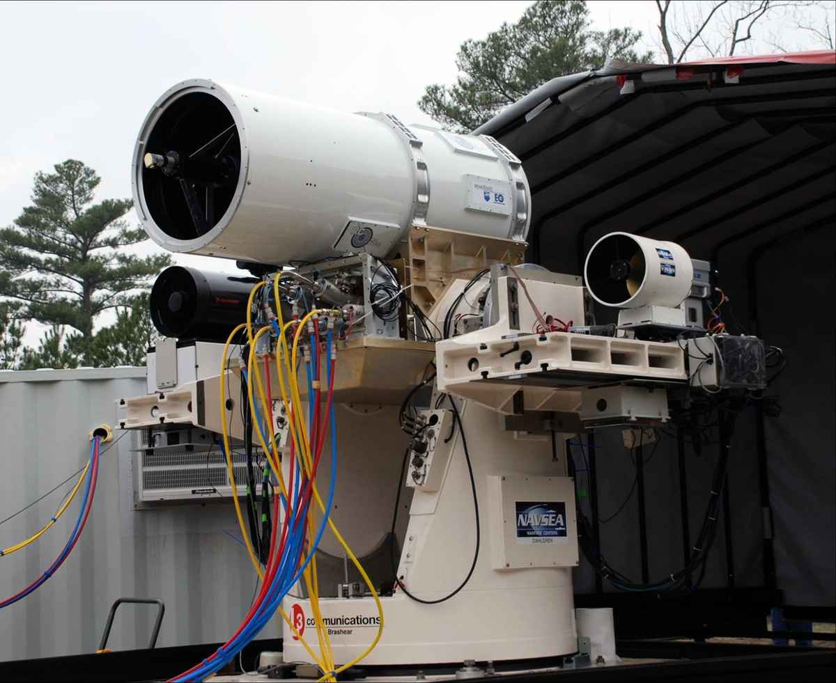 2010年1月19日，美國海軍發布的照片，顯示了定向能量武器和電動武器系統如何通過運動跟踪支架上的光束定向器發射激光，該支架由 MK-15 Phalanx 近距離武器系統控制。（維基百科/公共領域）