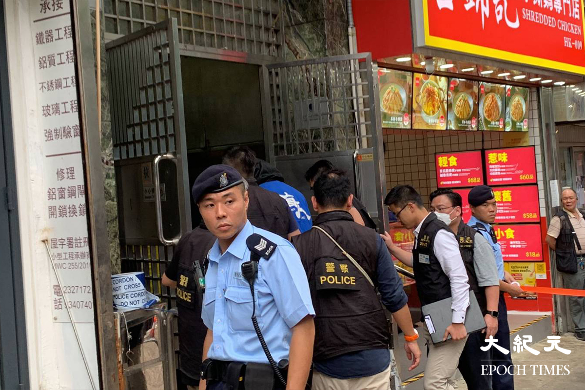 警員押解疑犯（藍色上衣者）返回案發現場。（梁智寧／大紀元)
