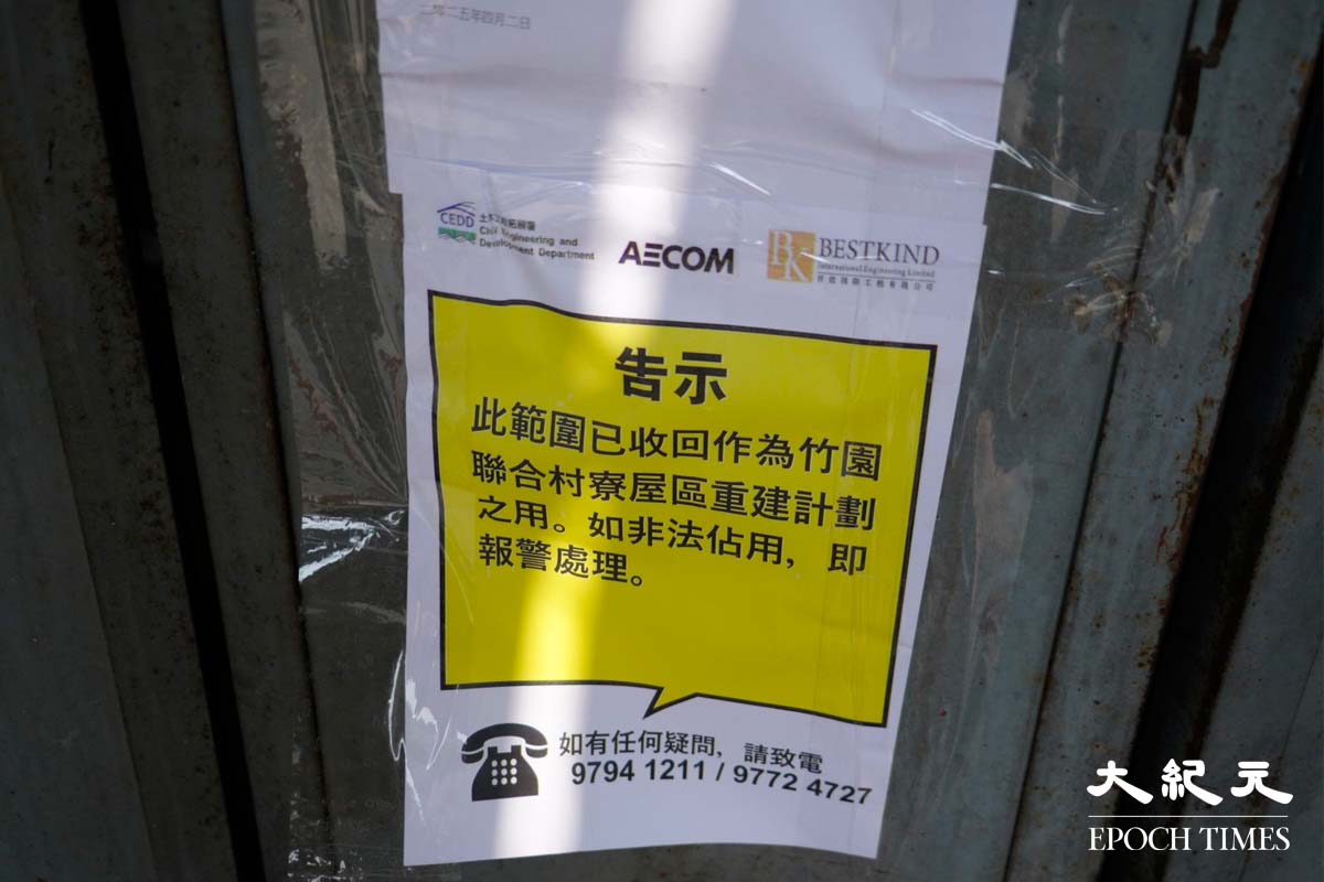 人員貼上告示，指有關土地已被政府收回。（蔡文昕／大紀元）