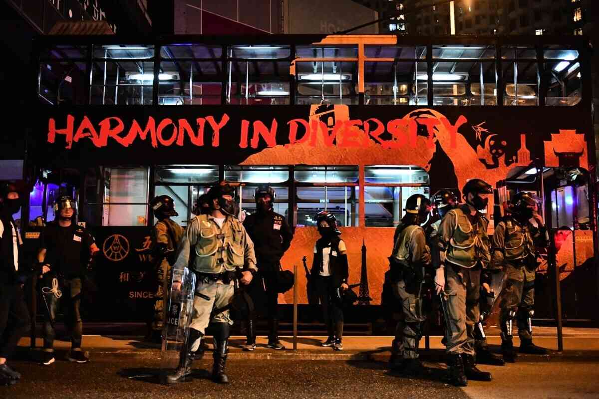 攝於2019年「反送中運動」期間,警方站在一架寫有「Harmony in diversity(和而不同)」字眼的電車前。Harmony in diversity意味一個平衡的社會,容許不同個體、文化和觀點共存,而不是被割裂或壓制。(ANTHONY WALLACE / AFP)