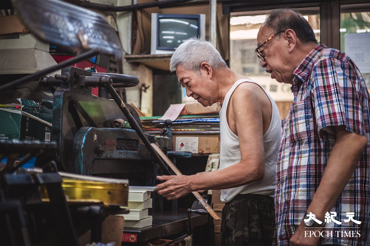 兩位老行尊在傳統的印刷機器前,別有一番感觸。(劉永康提供)