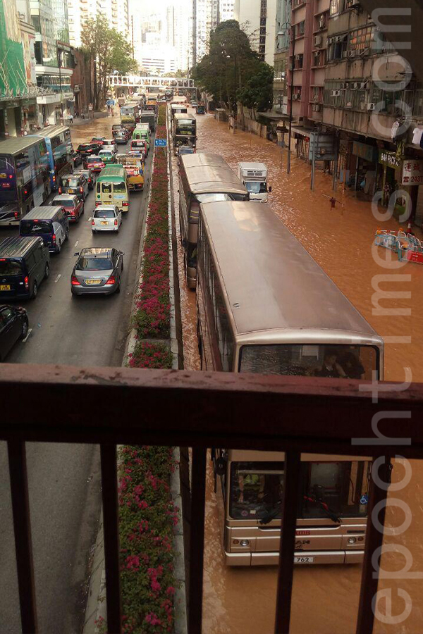 荃灣青山公路荃灣段，下午2時許有水管爆裂，大量水隨泥沙湧上路面，愉景新城至南豐中心之間一段馬路被淹浸。（讀者提供）