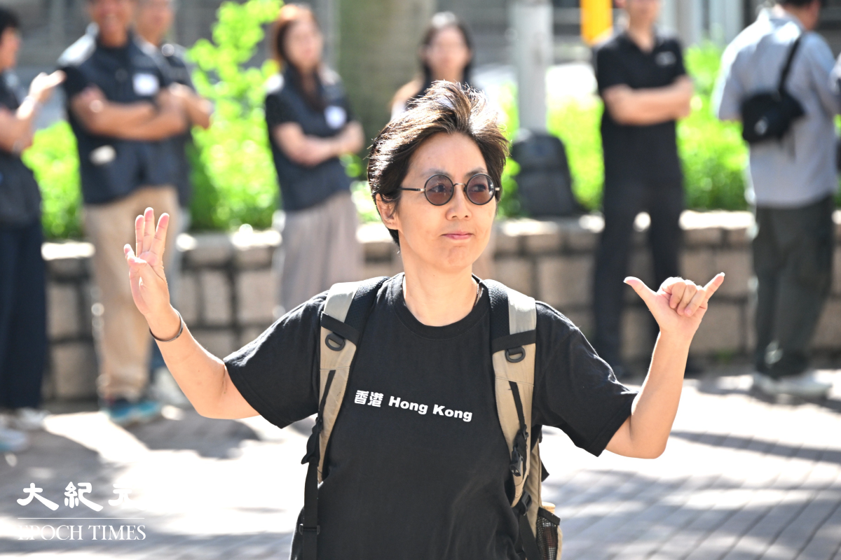 前支聯會常委劉家儀進入法院時高舉「六」和「四」的手勢。（吳銳略/大紀元）