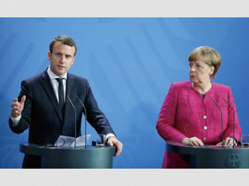 法國新總統馬克龍（左）出訪德國，與總理默克爾（右）召開聯合新聞發佈會。（網絡圖片）