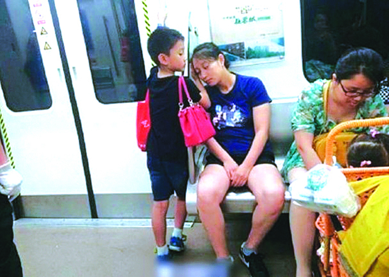 小男孩地鐵讓座 用手為媽媽墊著睡覺