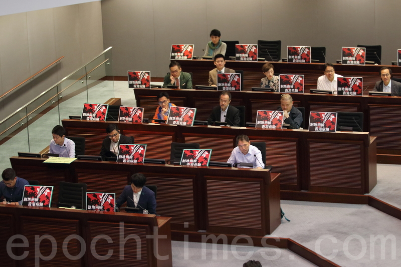 民主派議員在座位擺放「割地兩檢、香港危險」的標語牌，又批評政府至今仍不肯承諾進行公眾諮詢，是不聽民意。（蔡雯文／大紀元）