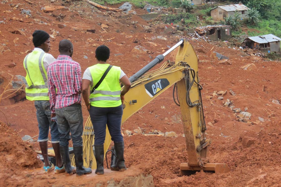 塞拉利昂首都發生嚴重的泥石流，救援人員在災難現場仔細搜尋是否有生還者。（AIDU BAH/AFP/Getty Images）