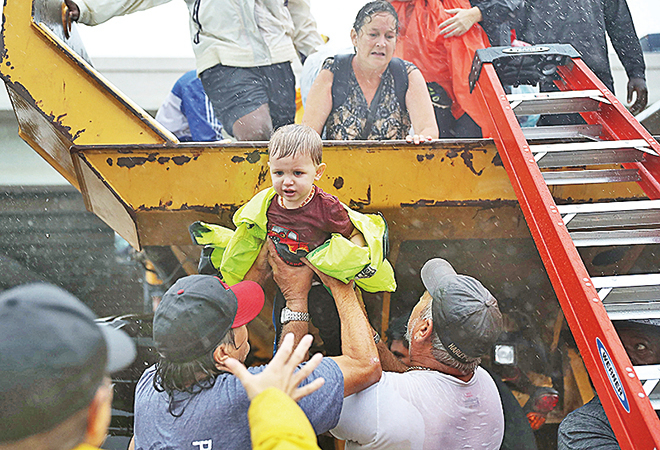 眾人一起幫助一名小童從救援的卡車上下來。（Getty Images）