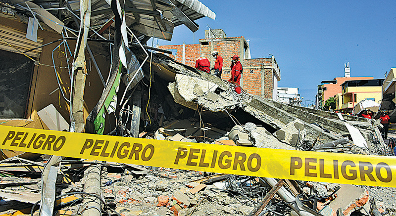  厄瓜多爾配備簡單照明裝備的救援人員，在瓦礫中徒手搜救生還者。（AFP）