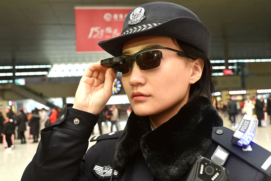 中共警方正在使用高科技墨鏡，可在擁擠的火車站發現疑犯，最新使用的面部識別技術引發人權組織的擔憂。圖為2018年2月5日，一名警察在中國河南省鄭州市鄭州東站佩戴一副帶有面部識別系統的智能眼鏡。（AFP Photo/China OUT）