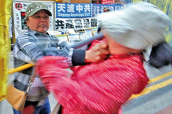 2014年3月22日青關會女成員陶桂香（左）被拍到揮拳毆打法輪功學員李女士。（大紀元資料圖片）