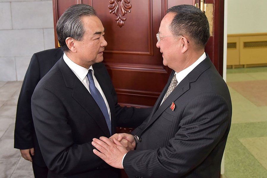 中共外交部長王毅（左）日前赴北韓訪問，接連與北韓外交部長李勇浩（右）、金正恩會面。（KCNA VIA KNS / AFP）