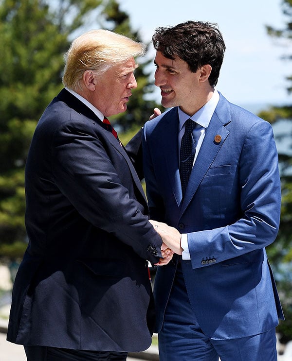 總統特朗普與加拿大總理杜魯多親切擁抱及握手。（Leon Neal/Getty Images）