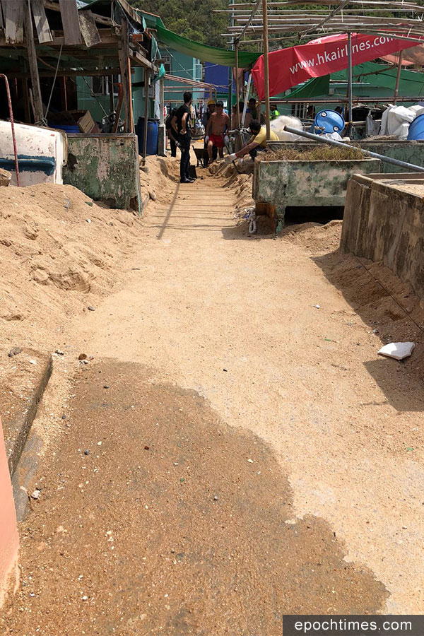 義工在清理行人通道上的海沙後，通道現已恢復，可供正常行走及搬運工具之用。（市民提供）
