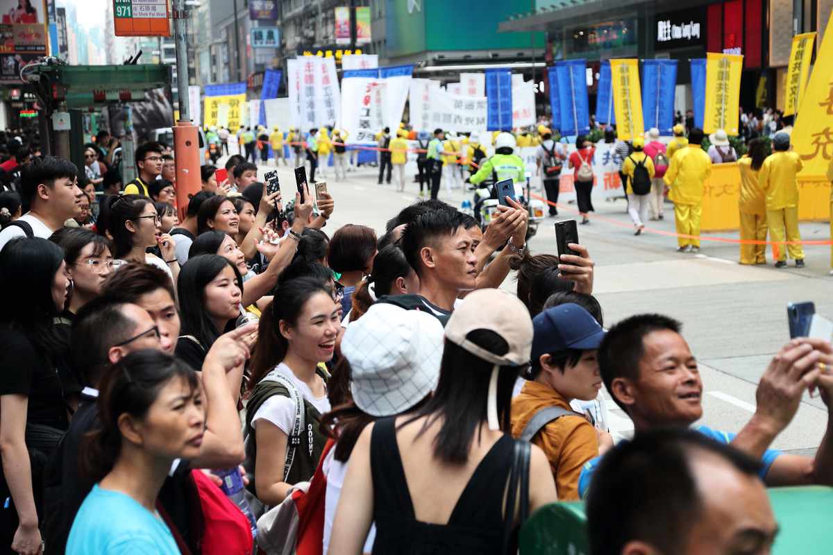 2018年10月1日「國殤日」，香港法輪功學員舉行盛大的反迫害集會遊行。壯觀的遊行隊伍經過旺角彌敦道，吸引市民遊客夾道觀看。（李逸/大紀元）