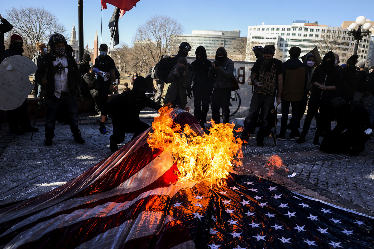 圖為2021年1月20日，在美國科羅拉多州丹佛市，美國共產黨和安提法組織成員在科羅拉多州議會大廈的台階上焚燒美國國旗。（Michael Ciaglo/Getty Images）