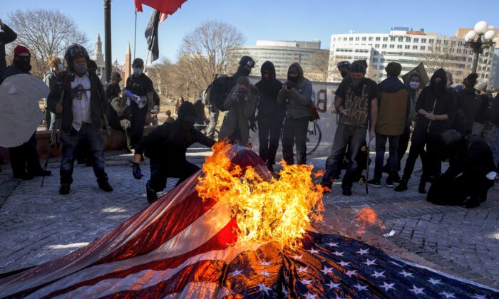 2021年1月20日，美國共產黨和其它「安提法」（Antifa）組織的成員，在科羅拉多州議會大廈的台階上，焚燒美國國旗。（Michael Ciaglo/Getty Images）