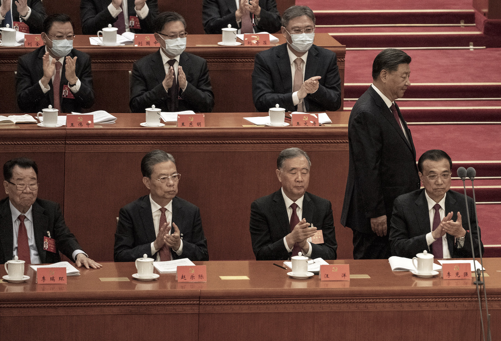 2022年10月16日，在中國北京人民大會堂，中共國家主席習近平（右上）在中共二十大開幕式上走過，下方的常委們一個個苦著臉。（Kevin Frayer/Getty Images）
