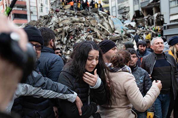 2023年2月6日，阿達納（Adana）發生7.8級地震後，土耳其救援人員在倒塌的建築物廢墟中尋找倖存者，現場一名婦女情緒激動。當天早些時候發生的7.8級地震已造成該國和敘利亞數千人死亡。（Can Erok/AFP via Getty Images）