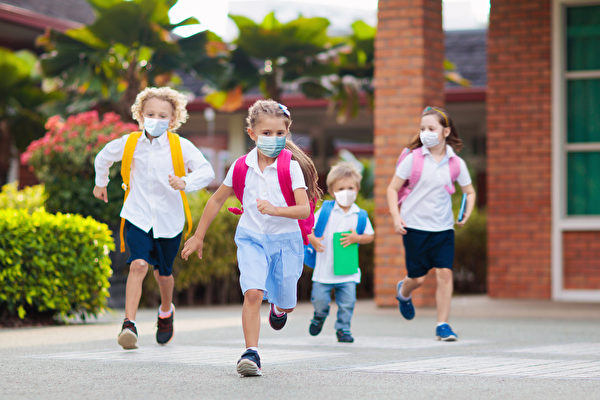 圖為疫情期間，西方學童戴口罩在校園內奔跑。（Shutterstock）