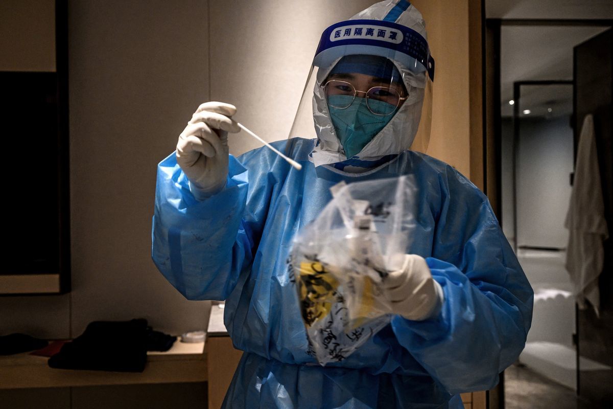 2022年2月1日，北京冬季奧運會前夕，一名醫務人員在北京延慶區一家酒店的客房內對一名酒店客人進行COVID-19檢測。（Jeff Pachoud/AFP via Getty Images）