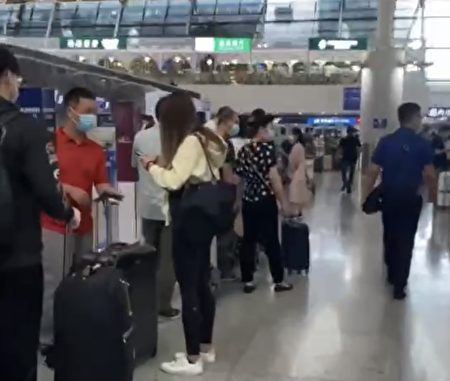 圖為上海浦東機場，回美上學的中國留學生大排長龍辦理登機。（影片截圖）