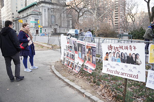 2023年2月5日，曼哈頓中央公園紀念李文亮醫師活動中，路過的紐約市民看著聲援遭中共拘捕的青年維權人士展板。（林宜君／大紀元）