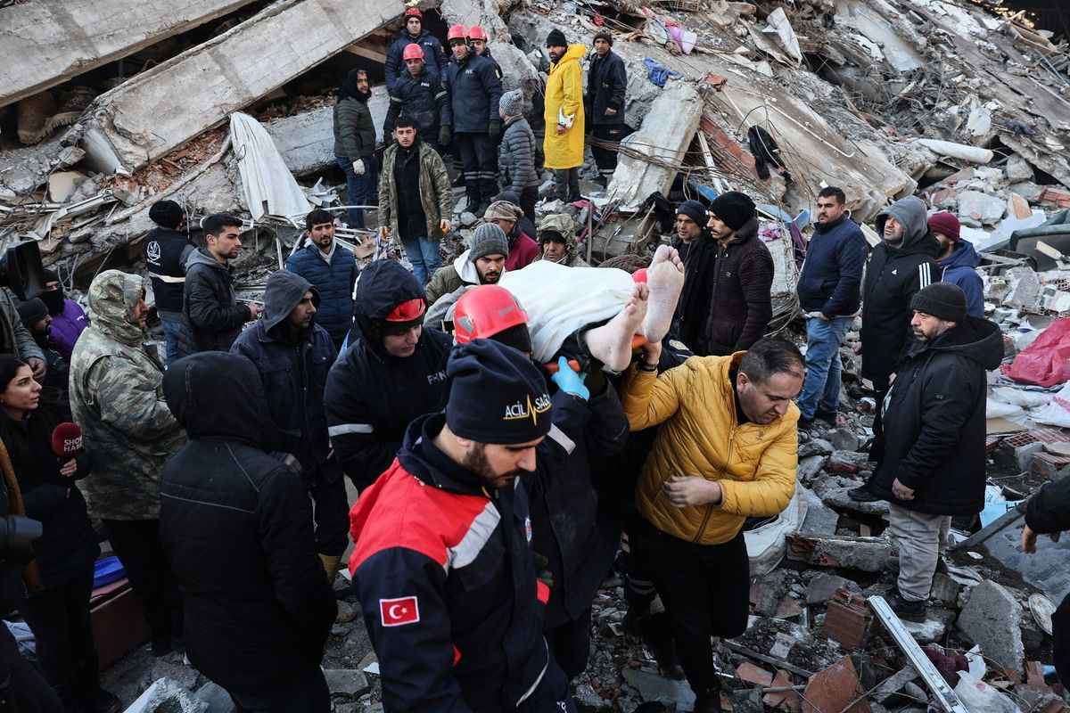 在土耳其東南部發生7.8級地震後的第二天，2023年2月7日，救援人員和志願者從土耳其南部的Kahramanmaras一座被毀建築物的廢墟中救出一名倖存者。（Adem Altan/Getty Images）