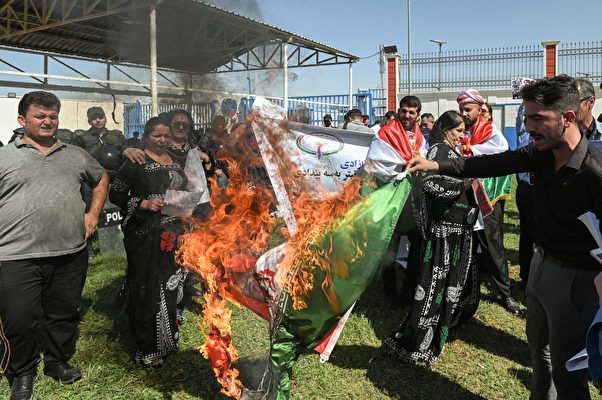 2022年9月24日,在位於伊拉克庫爾德自治區首府阿爾比勒(Arbil)的聯合國辦事處外,伊拉克和伊朗庫爾德人舉行示威,人們用焚燒伊朗國旗的方式譴責22歲的阿米尼(Mahsa Amini)在被伊朗當局關押期間死亡。(SAFIN HAMED/AFP via Getty Images)