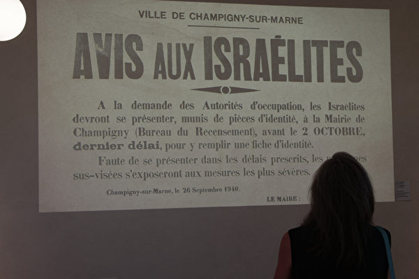 2022年7月11日，法國皮蒂維耶（Pithiviers），皮蒂維耶車站修復後，將成為納粹大屠殺紀念館。圖為媒體預覽期間，一名參觀者正看著牆上的文字介紹。（Geoffroy Van Der Hasselt/AFP）