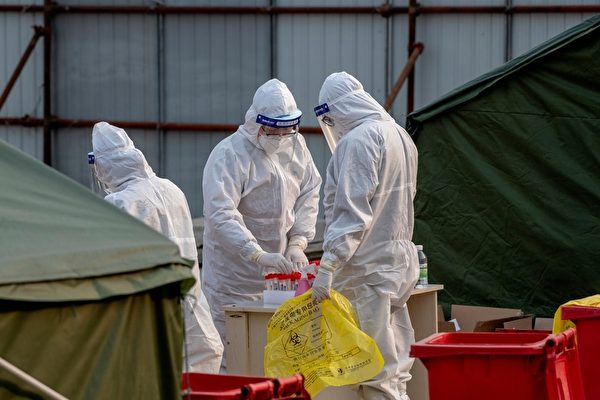 1月23日，在北京西城區的中共病毒測試現場，醫務人員忙於作核酸檢測的準備。（NOEL CELIS/AFP via Getty Images）