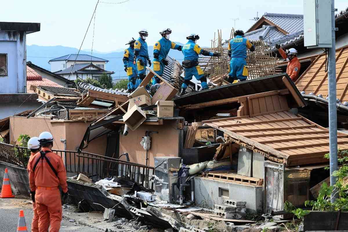 2026年7月30日，日本熊本縣八代市一棟房屋在地震中受損，救援人員在現場開展救援工作。（Jiji Press/AFP via Getty Images）