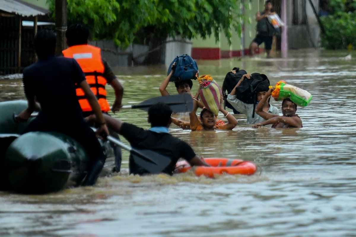2025年6月1日,印度特里普拉邦首府阿加爾塔拉(Agartala)附近的巴德卡爾村(Badkhal village),救援人員駕著船隻轉移受災民眾。(Abhisek Saha/Middle East Images/AFP via Getty Images)