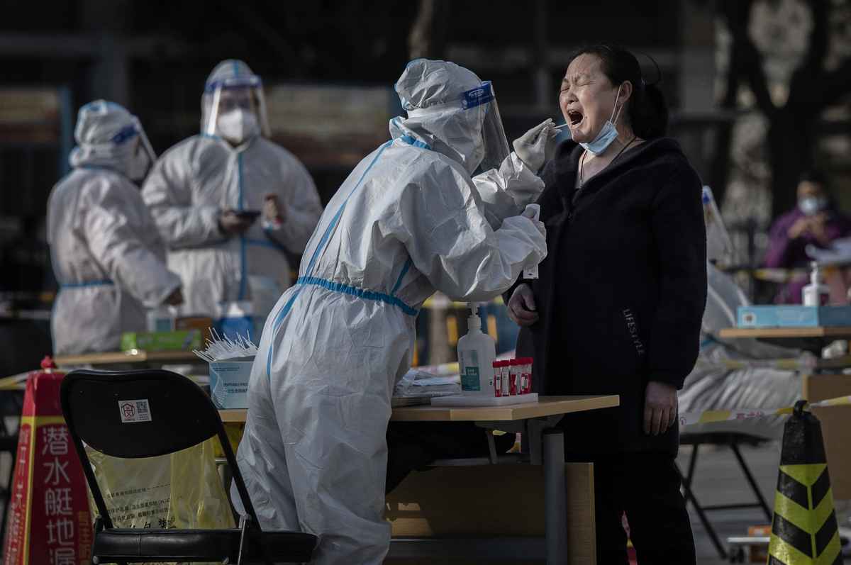 2022年4月6日，在北京發現新病例後，一名衛生工作者對當地居民進行核酸檢測。（Kevin Frayer/Getty Images）