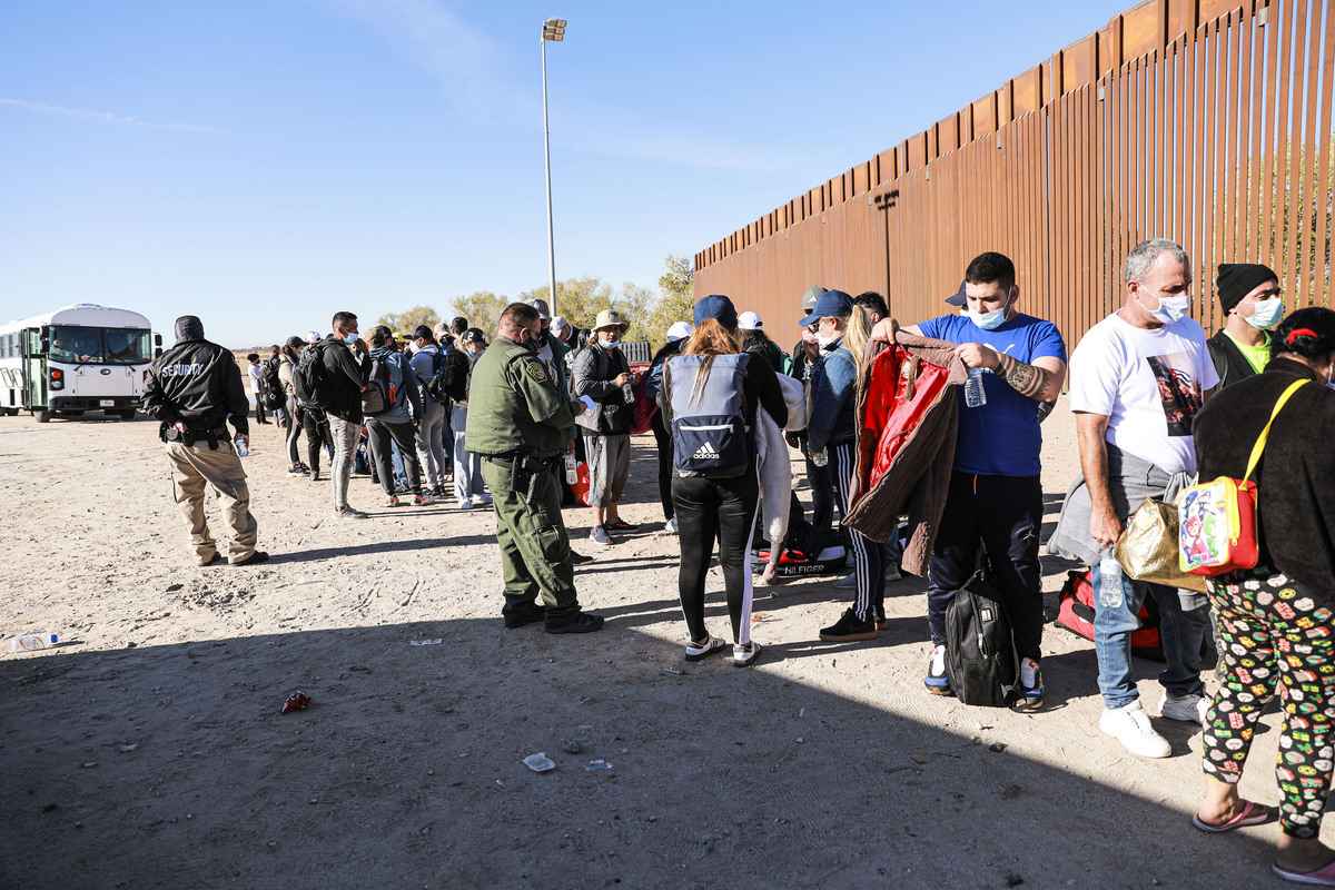 2021年12月10日，亞利桑那州尤馬市，一名邊境巡邏人員正在引導從墨西哥進入美國後，聚集在邊境圍欄邊的非法移民。 （Charlotte Cuthbertson/The Epoch Times）