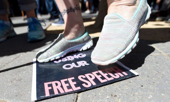2017年9月24日，保守派評論員米洛-亞安諾普洛斯（Milo Yiannopoulos）在加州大學伯克利分校發表演講後，一名婦女踩著言論自由的牌子。（Josh Edelson/AFP/Getty Images）