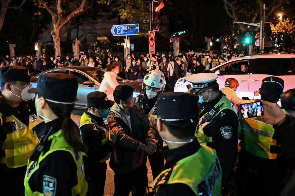 2022年11月27日，在上海，警察與一名男子對峙，他們封鎖了以烏魯木齊普通話命名的烏魯木齊路，該地區在新疆烏魯木齊發生致命火災後，前一天晚上發生了反對中共清零政策的抗議活動。（HECTOR RETAMAL/AFP via Getty Images）