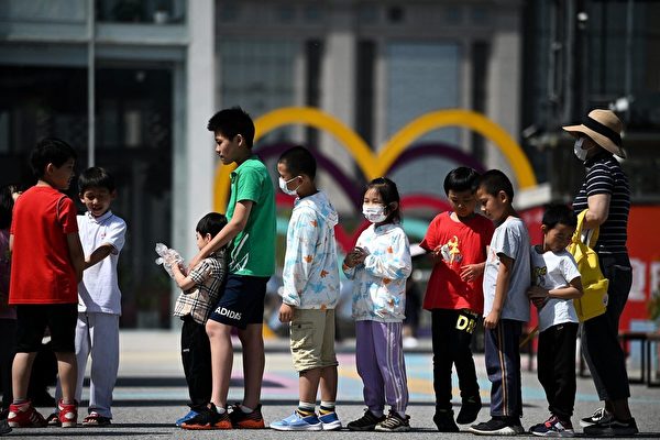 2021年5月31日，北京政府宣佈將允許一對夫婦生育三個孩子。圖為6月1日北京兒童排隊玩滑梯的情景。（NOEL CELIS/AFP via Getty Images）