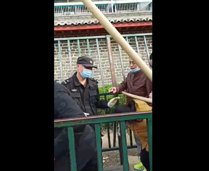 中共國家信訪局通道橫卡大木棍 讓訪民鑽過去