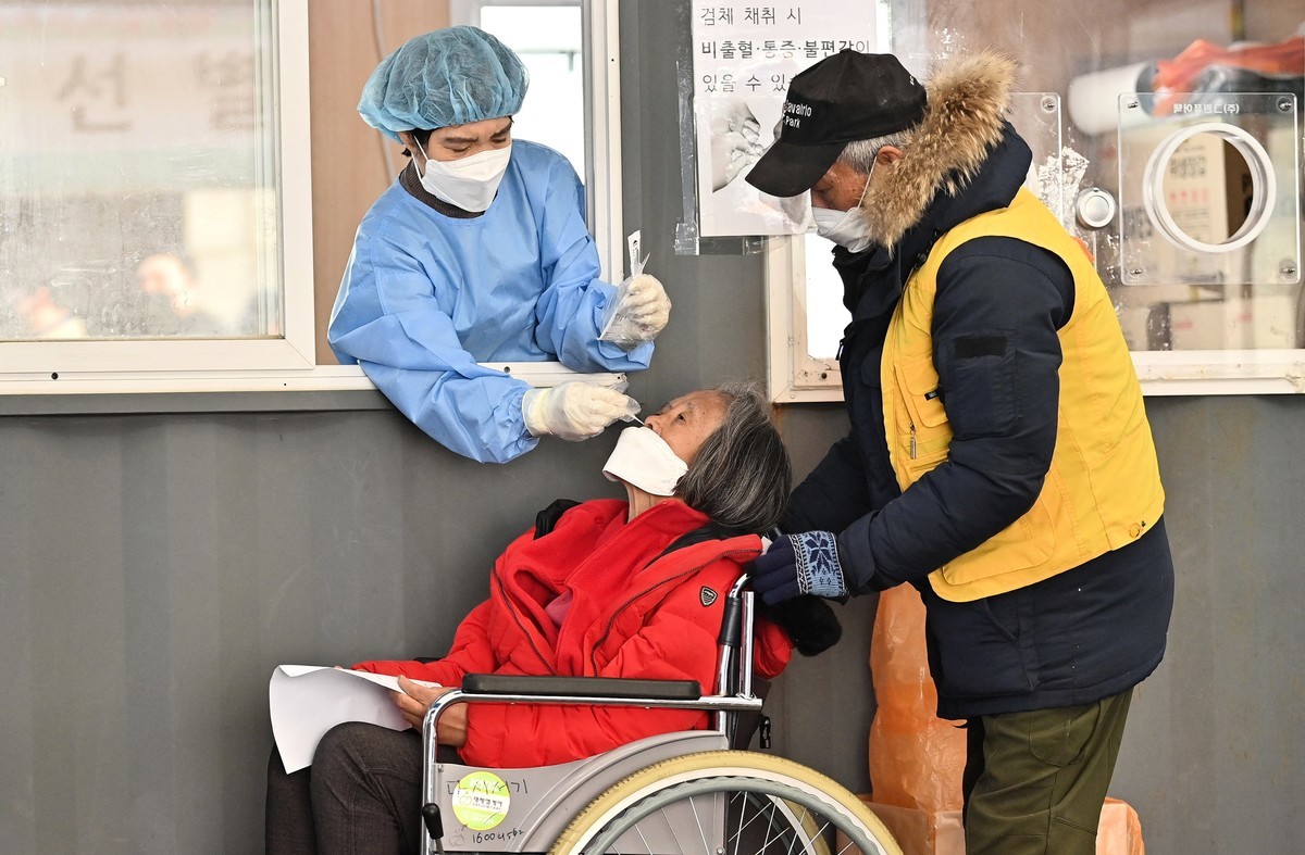 2022年1月26日，在首爾的一個COVID-19病毒檢測中心，一名醫務人員（L-in 展位）正在採集鼻拭子。（Jung Yeon-je/AFP via Getty Images）