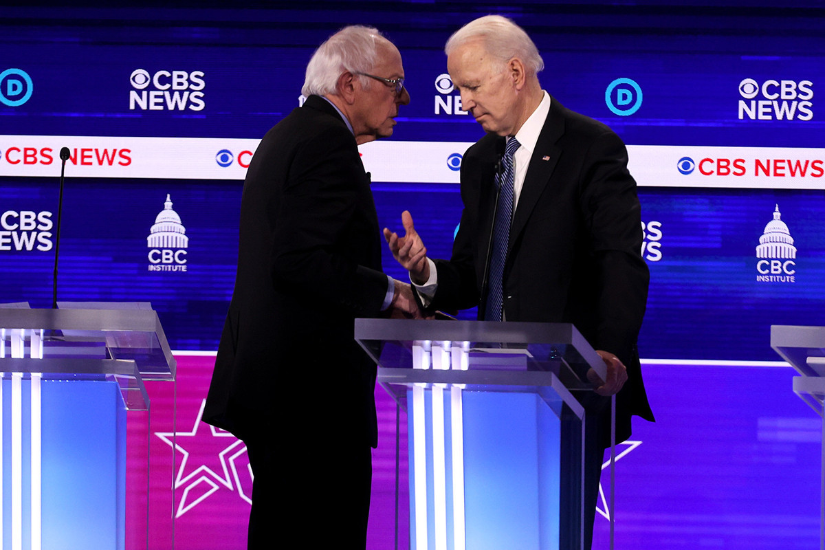 圖為2020年2月25日，民主黨總統候選人伯尼・桑德斯（Bernie Sanders，左）和前副總統喬・拜登（Joe Biden）在南卡羅來納州的民主黨總統初選辯論會的休息時間交談。（Win McNamee/Getty Images）