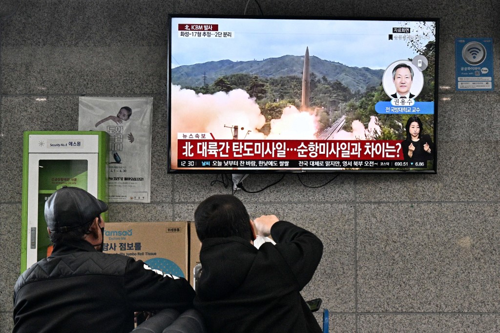 2022年12月5日，北韓發射130餘發炮彈，加劇朝韓緊張局勢。圖為2022年11月3日，遊客在南韓東部鬱陵島觀看電視播放的北韓導彈試射檔案照。（Anthony WALLACE/AFP）