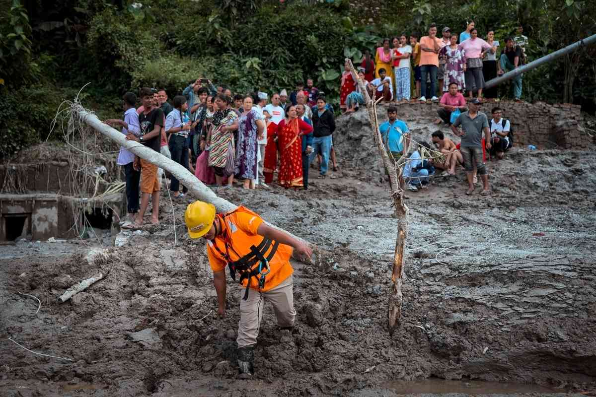 2026年8月27日，在尼泊爾努瓦科特縣（Nuwakot）特里蘇里（Trishuli）發生山洪的第二天，居民聚在一起，查看災損情況。（Ezra Acayan/Getty Images）